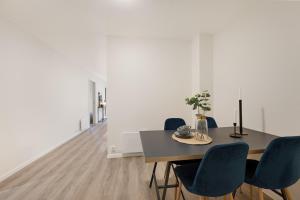 a dining room with a table and blue chairs at Apartment in Frogner Lillestrøm - Modern and Central in Lillestrøm