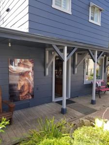 une maison bleue avec un grand tableau sur son côté dans l'établissement Motel Shantik, à Montebello