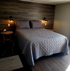 a bedroom with a large bed and a table at Motel Shantik in Montebello