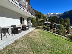 a balcony of a house with a table and chairs at Affittacamere Buenavista in Champoluc