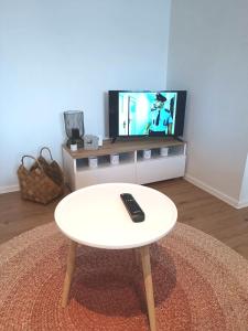Zoo Karlovarská Apartment في بلزن: طاولة قهوة بيضاء في غرفة معيشة مع تلفزيون