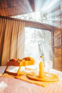 a table with a plate of food and a window at Pousada Alpes da Araucárias in São Francisco de Paula