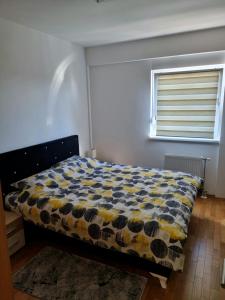 1 dormitorio con 1 cama con edredón amarillo y azul en Apartman Court Prijedor, en Prijedor