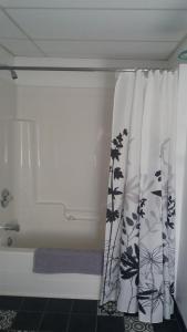 a bathroom with a shower with a shower curtain at Motel Shantik in Montebello