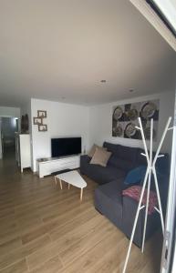 sala de estar con sofá azul y TV en Apartamento Belva, en Puerto del Carmen
