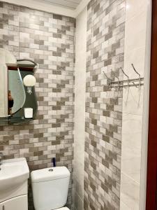 a bathroom with a toilet and a sink and a mirror at Аппартаменты в самом центре Площадь-Вал in Chernihiv