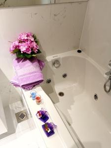 een badkamer met een vaas met bloemen en een bad bij Downtown luxury apartment Emili in Split