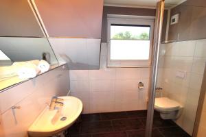 a bathroom with a sink and a toilet and a window at Luxusferienhaus Seevilla Monaco am Fleesensee in Göhren-Lebbin +38 photos