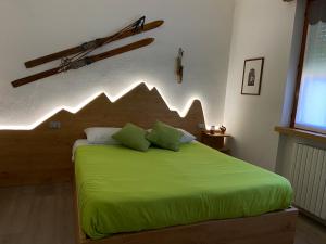 a bedroom with a green bed with a wooden headboard at BoTép ai Tigli in San Pellegrino Terme