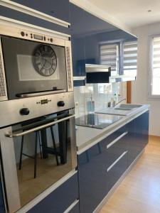a kitchen with a stove and a microwave at Studio les pieds dans l'eau - plage à proximité in Le Relecq-Kerhuon