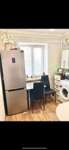 a kitchen with a refrigerator and a table with chairs at Аппартаменты в самом центре Площадь-Вал in Chernihiv