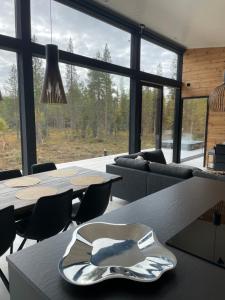 Villa JoenPolku Ruka في روكا: غرفة بها طاولات وكراسي ونافذة كبيرة