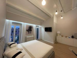 una camera da letto con un grande letto bianco e una finestra di Off House Borgo Suite, Nettuno a Nettuno