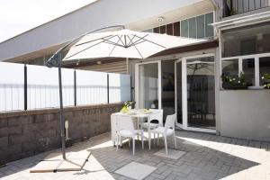 a patio with a table and chairs and an umbrella at A due passi dal Duomo in Acireale