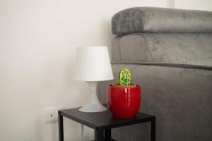 a red lamp on a table next to a bed at A due passi dal Duomo in Acireale