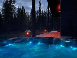 a swimming pool with blue lights in a house at Modern Villa JoenPolku Ruka With jacuzzi, sauna and scenic views in Ruka