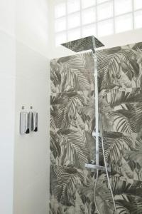 uma casa de banho com um chuveiro com um mural de folhas em A due passi dal Duomo em Acireale