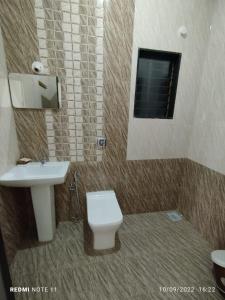 a bathroom with a sink and a toilet and a mirror at Hotel Kavijay Sea View in Dapoli