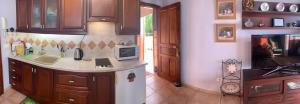 a kitchen with wooden cabinets and a sink and a stove at Apartamento MAR Y TEIDE in Sauzal