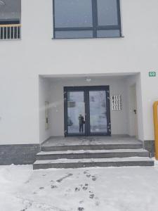 a person standing in front of a door in the snow at Whitehouse apartment in Bjelašnica