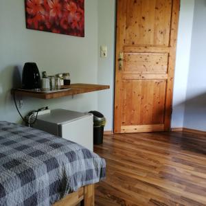 um quarto com uma porta de madeira e um piso de madeira em Auerandzimmer em Nienhagen