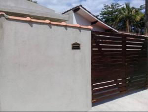 a building with a wooden fence next to a house at Linda acomodação a poucos metros da praia in Caraguatatuba
