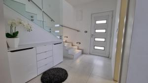 un corridoio bianco con scale e porta bianca di Holiday House Gavran a Vodice Altre 17 foto