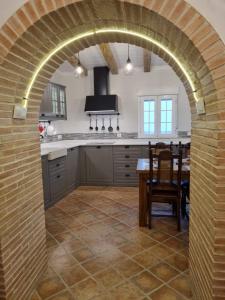 Un arco en una cocina con mesa y comedor en Casa Flora - Casa rural con encanto en El Carpio de Tajo