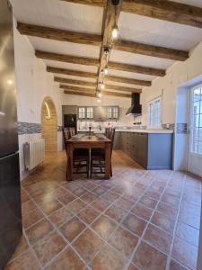 cocina grande con mesa de madera y sillas en Casa Flora - Casa rural con encanto en El Carpio de Tajo