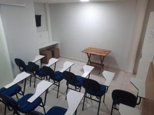 una habitación con un montón de sillas y una mesa en Pousada Avenida, en Teixeira de Freitas