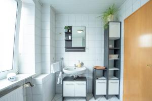 a white bathroom with a sink and a mirror at Wild West Hotel in Fichtelberg