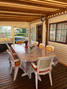 - une table à manger et des chaises sur une terrasse dans l'établissement Mobilhome, à Noyelles-sur-Mer