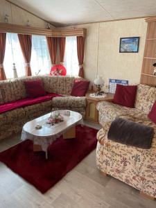 Sala de estar con sofás y mesa de centro en Mobilhome en Noyelles-sur-Mer