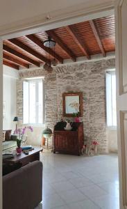 sala de estar con sofá y pared de piedra en Ma mer, en Naxos Chora
