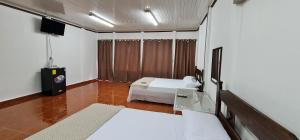 pokój hotelowy z łóżkiem i telewizorem w obiekcie Sleep&Go! Cabina Cuadruple en Siquirres Centro -and rafting tour! w mieście Siquirres