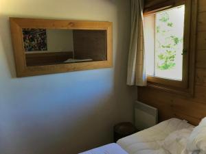 レ・キャローズ・ダラッシュにあるAppartement cosy 4-6 personnes aux carroz d Arrachésのベッドルーム1室(鏡、ベッド1台、窓付)