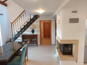 a living room with a staircase and a table and a fireplace at Apartment Sun view in Mali Lošinj