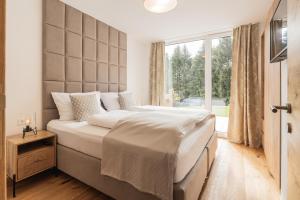 a bedroom with a large bed with a large window at Granit Appartements in Mauterndorf