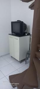 a tv sitting on top of a cabinet in a room at Matinhos 150 metros da praia in Matinhos