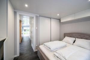 Recreatiepark Maas en Bos في فيليلويْ: غرفة نوم بسرير كبير مع شراشف بيضاء