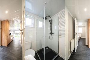 een badkamer met een douche en een glazen deur bij Recreatiepark Maas en Bos in Wellerlooi
