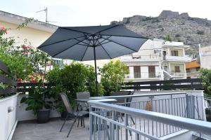 - Balcón con mesa y sombrilla en Michaela's guesthouse, en Nauplia