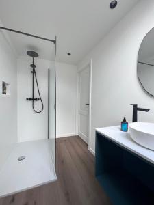 uma casa de banho branca com um lavatório e um espelho em Maison Georges em Turnhout