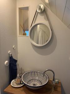uma casa de banho com um lavatório e um espelho em Mysigt rum i villa med egen ingång och nära havet. em Åhus