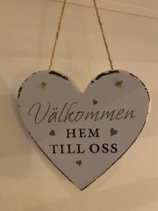 un signo en forma de corazón colgando del techo en Mysigt rum i villa med egen ingång och nära havet. en Åhus