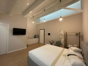 una grande camera da letto con un letto e una televisione di Off House Borgo Suite, Nettuno a Nettuno