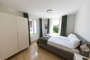 a bedroom with a bed and two windows at Swiss Stay - 2 Bedroom Apartment close to ETH Zurich in Zürich