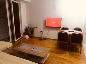 a living room with a flat screen tv and a table at Bisera in Skopje