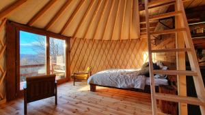 a bedroom with a bed in a room with a ladder at Jurty na Polanie Karol&Franek in Owczary