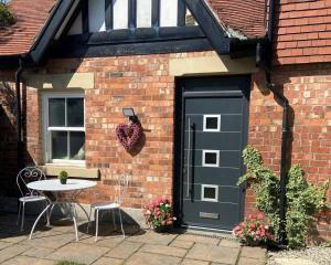 a black door on a brick building with a table at Cosy Cottage in Lytham St Annes - close to beach in Saint Annes on the Sea
